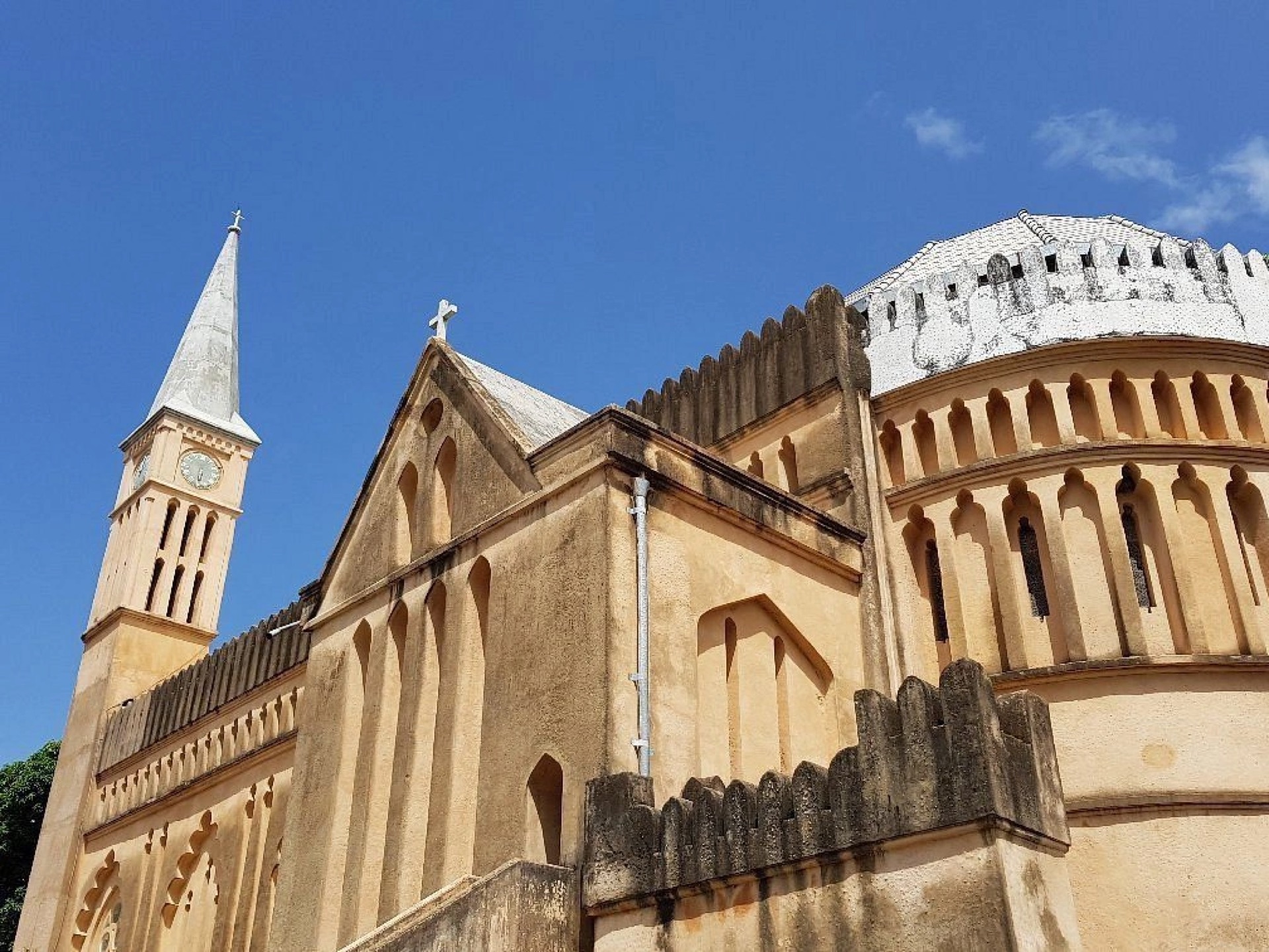 The coral-stone walls, dome and clock tower of Christ Church Cathedral in Stone Town, Zanzibar